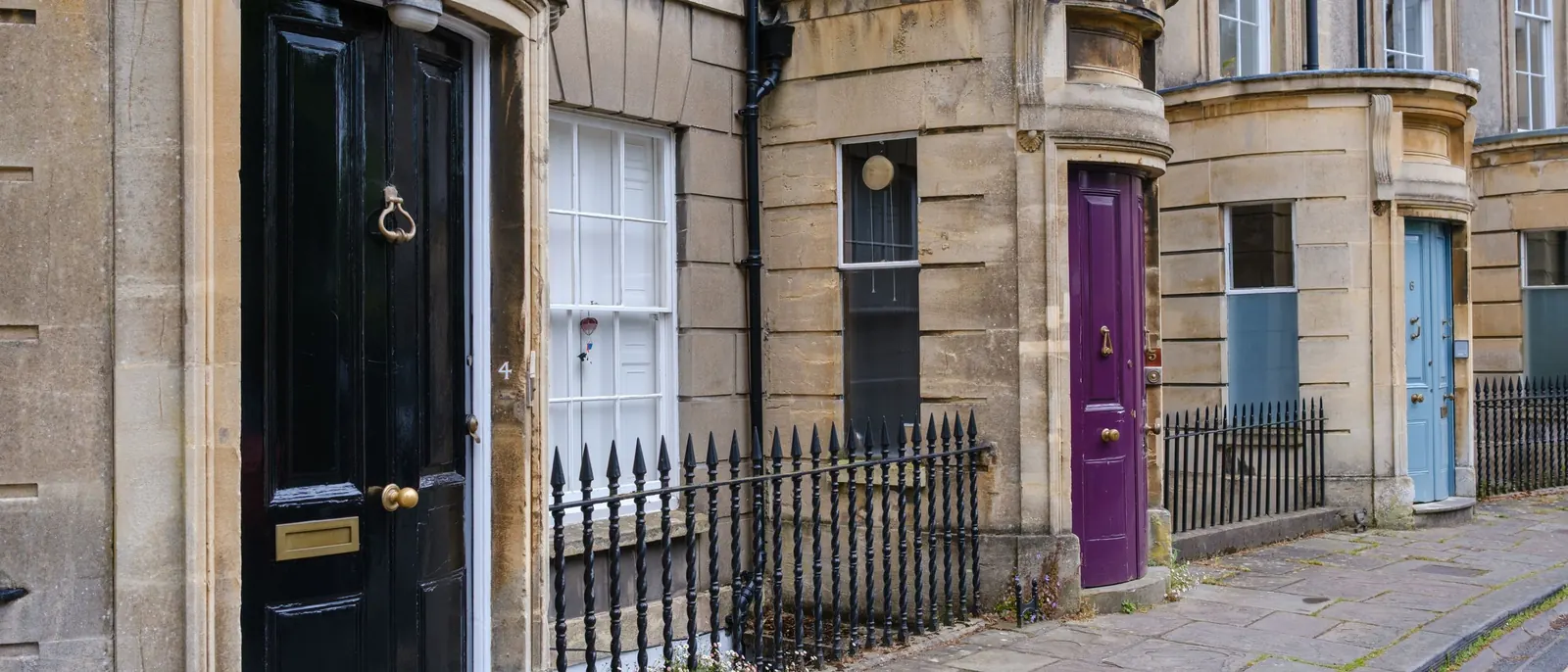 A row of Georgian front doors on a terraced street in Bath