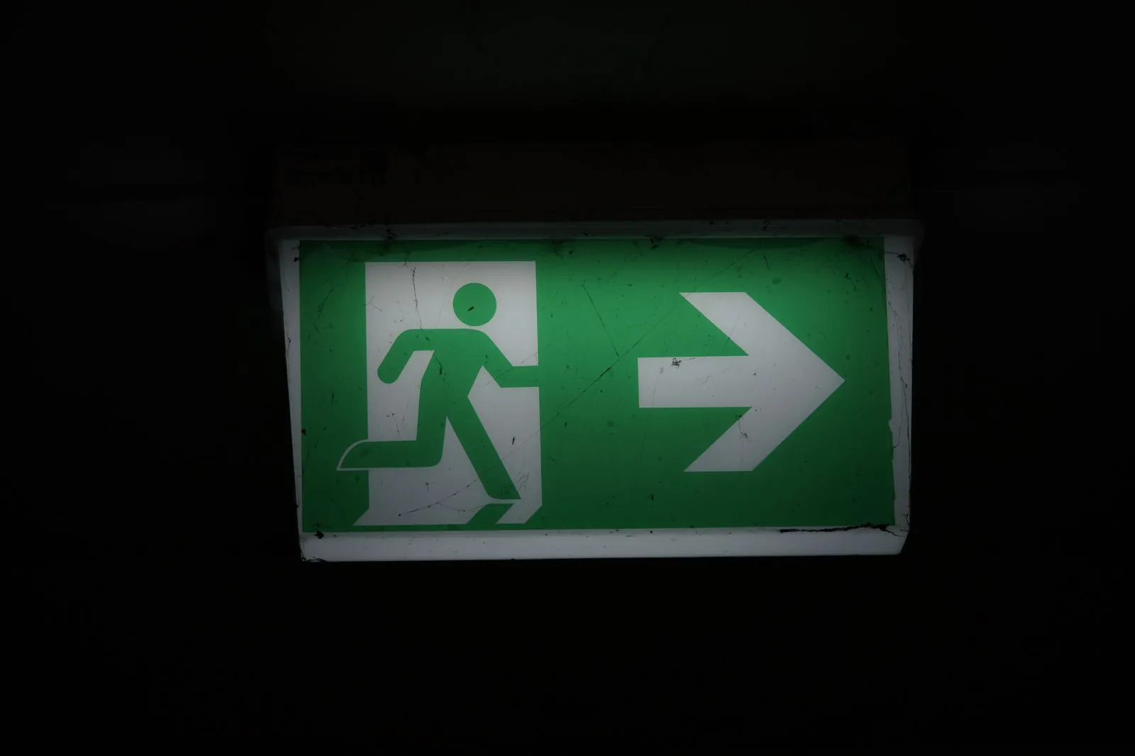 Green fire exit sign above a corridor in a residential building